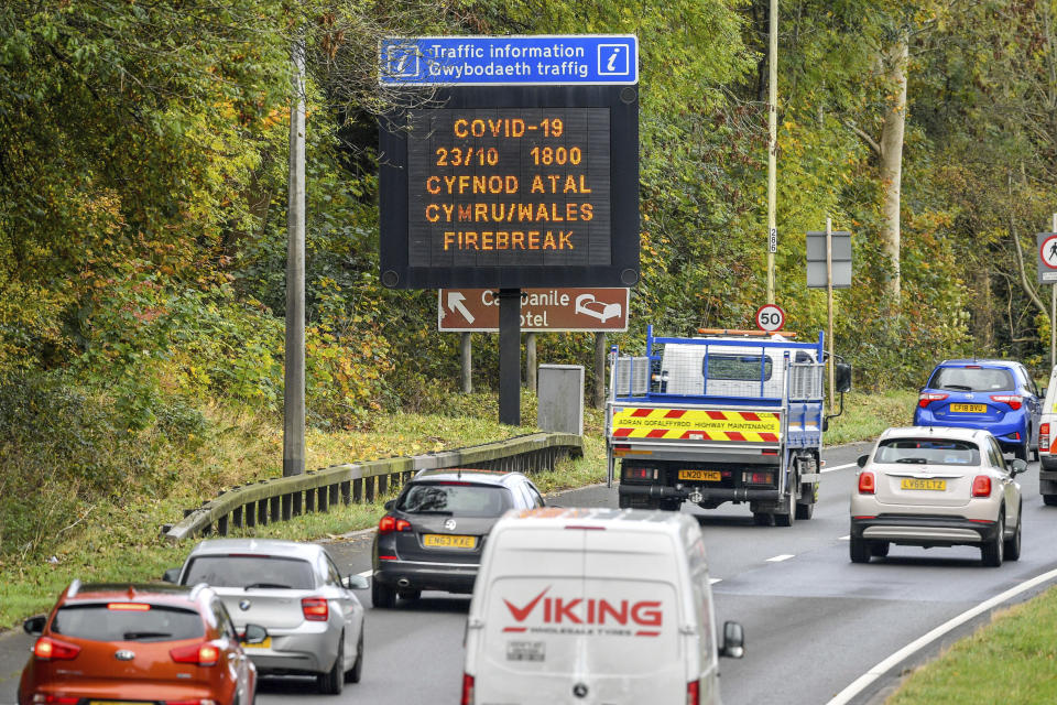 A matrix sign on the A48(M) heading towards Cardiff informing motorists to Wales entering a "firebreak" lockdown, Friday, Oct. 23, 2020. A police force in England says it will try to stop people from leaving Wales, which has started a 17-day lockdown to slow the spread of COVID-19. The Gloucestershire Constabulary says it will patrol routes from Wales and pull over drivers they believe are making long journeys. Travelers without a good excuse will be asked to turn around. (Ben Birchall/PA via AP)