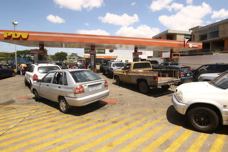 People with their vehicles wait in line to refuel at a gas station of the state oil company PDVSA in Ciudad Guayana, Venezuela, May 17, 2019. REUTERS/William Urdaneta