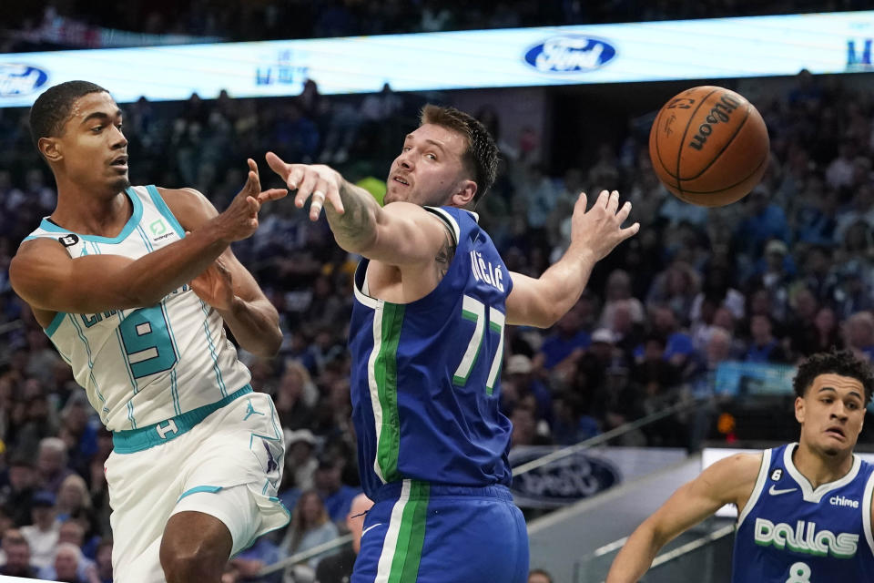 Charlotte Hornets guard Theo Maledon (9) passes the ball against Dallas Mavericks defenders Luka Doncic (77) and Josh Green (8) during the first half of an NBA basketball game in Dallas, Friday, March 24, 2023. (AP Photo/LM Otero)