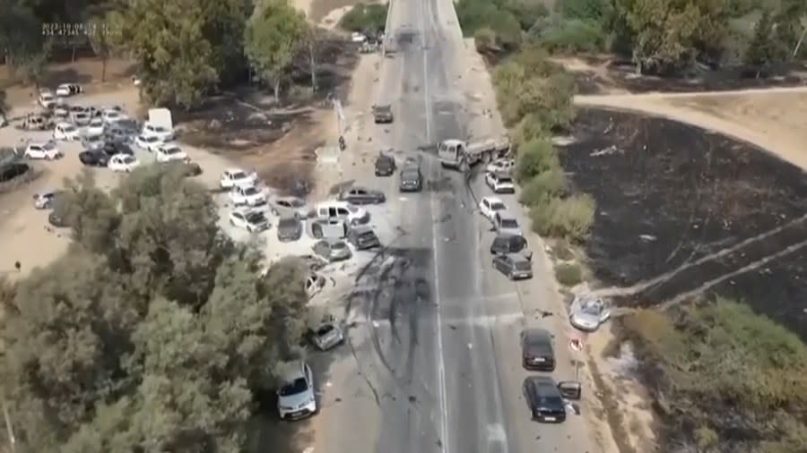 This image from video provided by South First Responders shows charred and damaged cars along a desert road after an attack by Hamas militants at the Tribe of Nova Trance music festival near Kibbutz Re’im in southern Israel on Saturday, Oct. 7, 2023. (South First Responders via AP)
