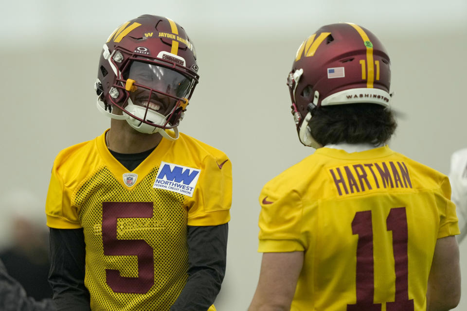 Washington Commanders first round draft pick quarterback Jayden Daniels (5) talks with quarterback Sam Hartman (11) during an NFL rookie minicamp football practice in Ashburn, Va., Friday, May 10, 2024. (AP Photo/Susan Walsh)