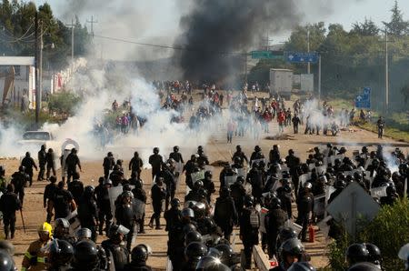 Protesters from the National Coordination of Education Workers (CNTE) teachers’ union clash with riot police officers during a protest against President Enrique Pena Nieto's education reform, in the town of Nochixtlan, northwest of the state capital, Oaxaca City, Mexico June 19, 2016. REUTERS/Jorge Luis Plata