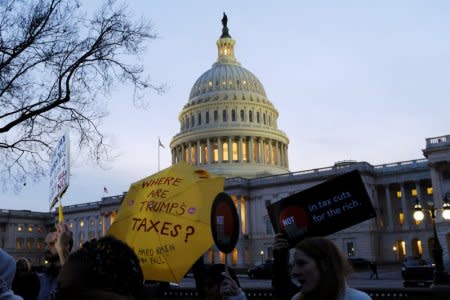 FILE PHOTO: Demonstrators gather outside the U.S. Capitol to protest the Republican tax plan as it works through the Senate in Washington November 30, 2017. REUTERS/James Lawler Duggan