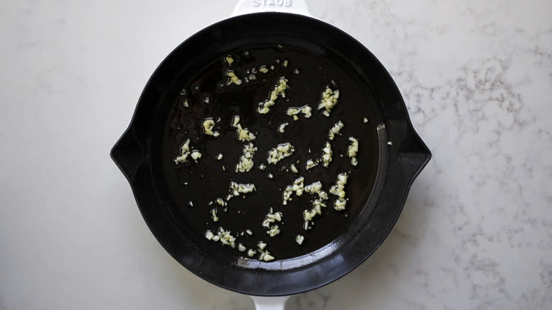 sauteeing minced garlic in skillet