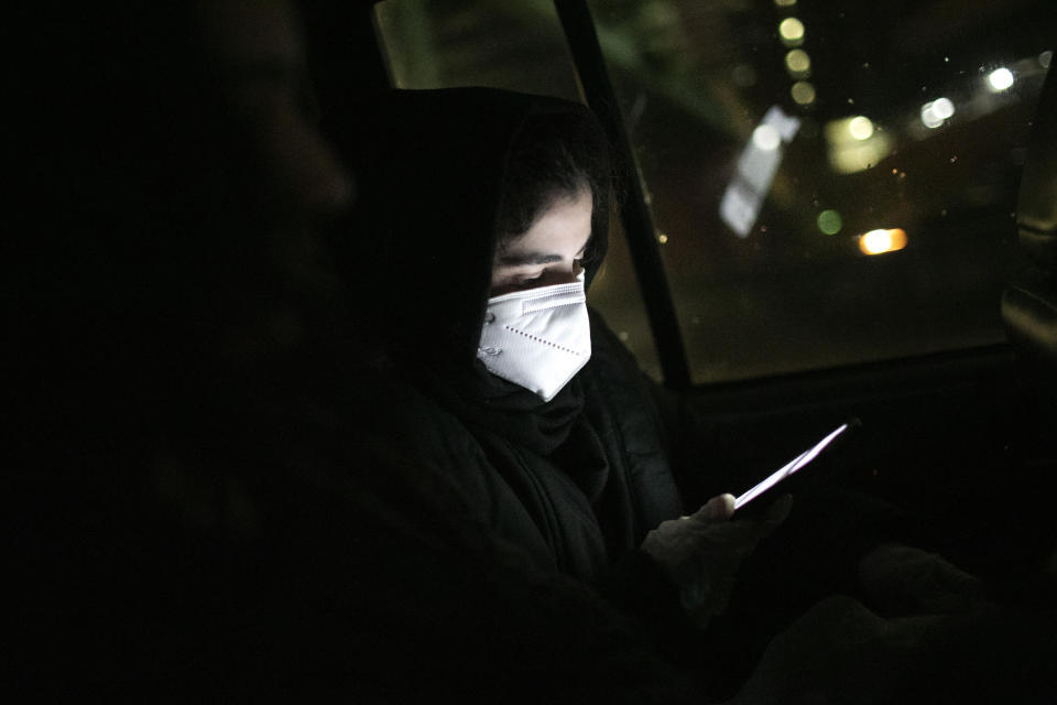 Dania Darwish, 27, director of the Asiyah Women's Center checks for updates on her cellphone as she travels with other volunteers of Muslims Giving Back, to Herald Square where they will hand out food to the hungry, in New York, on Sunday, April 26, 2020. (AP Photo/Wong Maye-E)