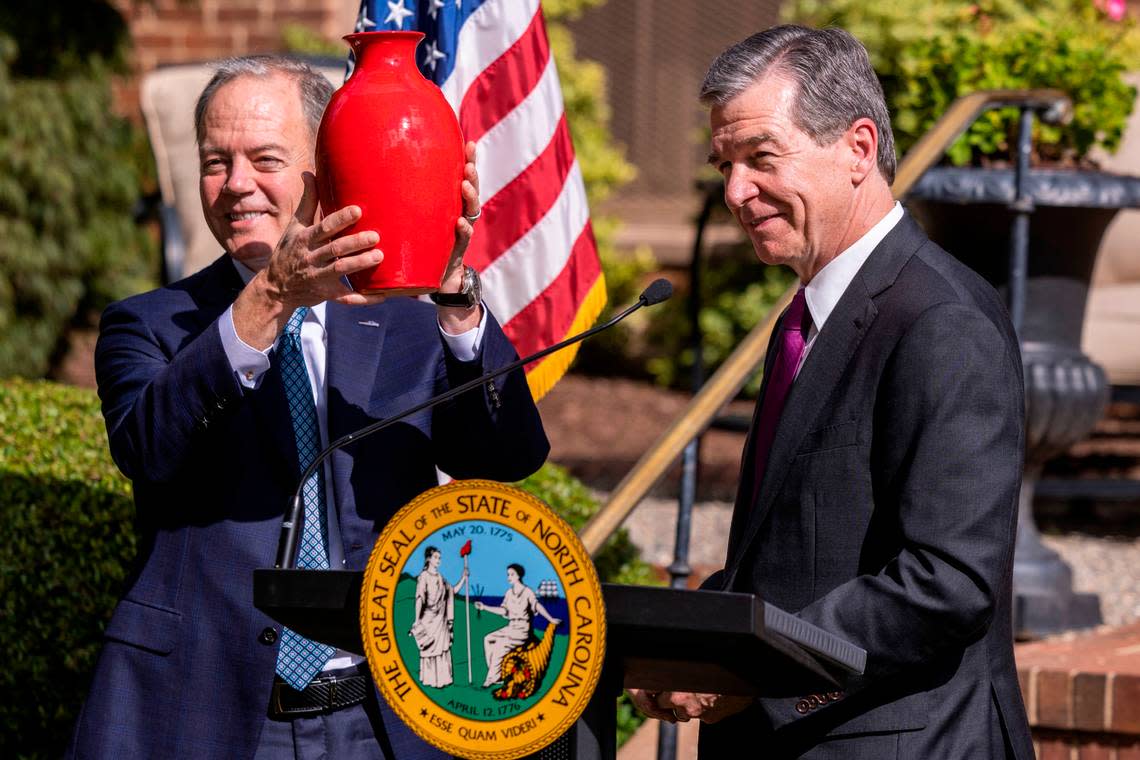 Gov. Roy Cooper, right, presents Wolfspeed CEO Gregg Lowe with a piece of pottery as a gift during an economic development announcement ceremony at the Executive Mansion Friday, Sept. 9, 2022. Wolfspeed, a Durham silicon chip manufacturer, will build a new factory in Chatham County promising 1,800 new jobs.