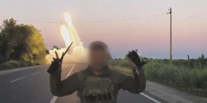 A still from footage shared by the Ukrainian Defense Ministry shows a soldier, whose face is obscured, raise his hands in a 