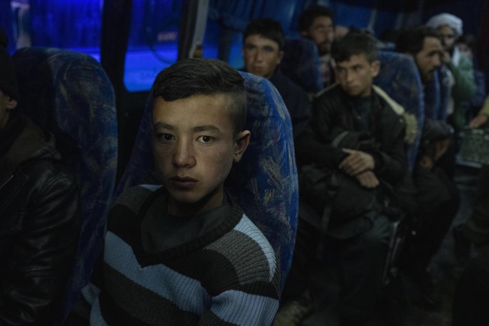 Afghans sits in a bus in Herat, Afghanistan, Tuesday , Nov. 23, 2021, for a 300-mile trip south to Nimrooz near the Iranian border. Afghans are streaming across the border into Iran, driven by desperation after the near collapse of their country's economy following the Taliban's takeover in mid-August. In the past three months, more than 300,000 people have crossed illegally into Iran, according to the Norwegian Refugee Council, and more are coming at the rate of 4,000 to 5,000 a day. (AP Photo/Petros Giannakouris)