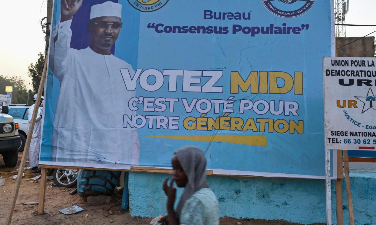 <span>A pedestrian walks past a campaign poster of Mahamat Idriss Déby Itno in N'Djamena.</span><span>Photograph: Issouf Sanogo/AFP/Getty Images</span>