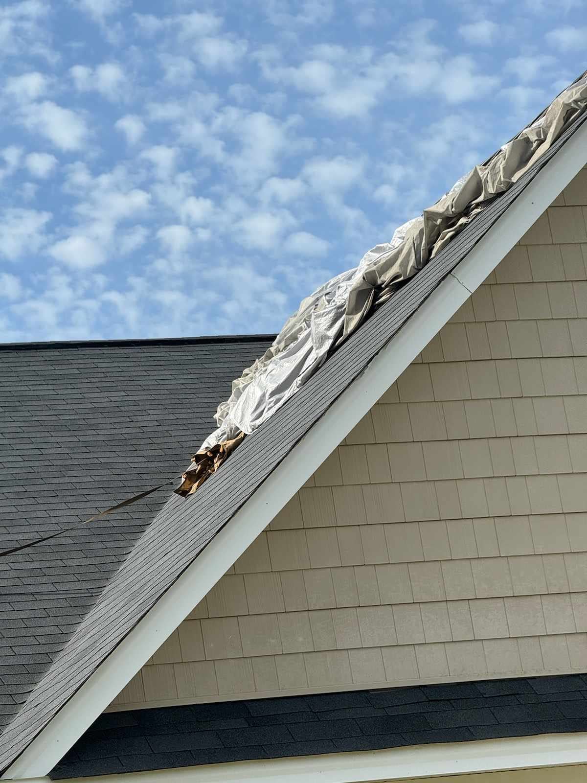 A military-issued parachute rests atop of a Fayetteville home after a Fort Liberty paratrooper missed the drop zone and landed there on Tuesday, April 30, 2024.