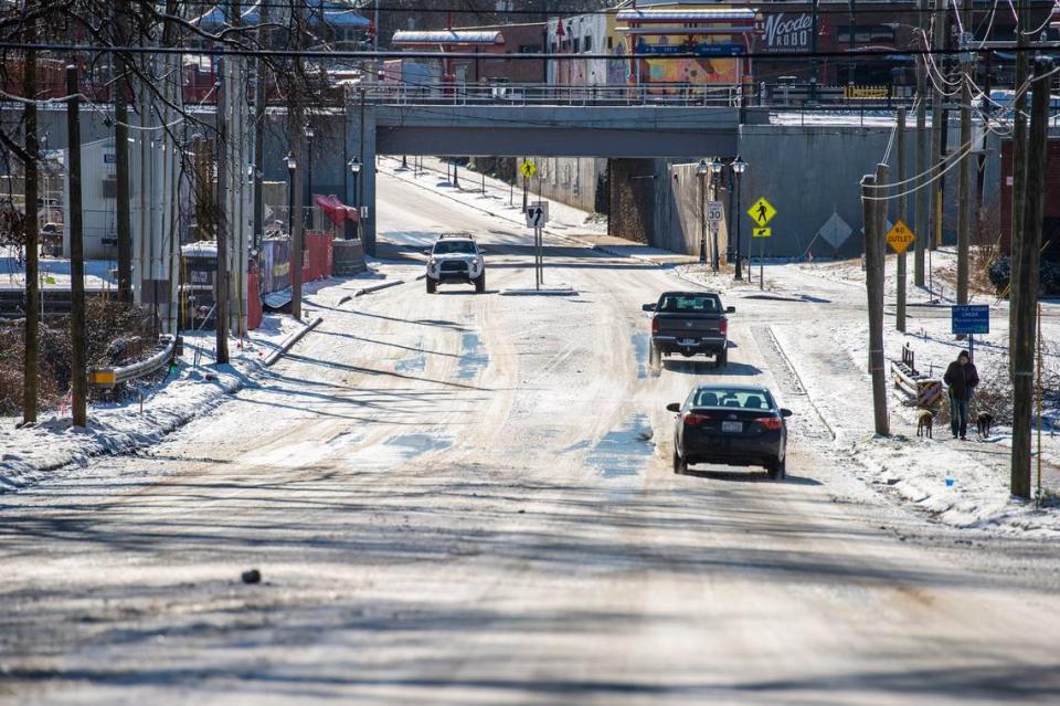 Cars drive down a snow and ice-covered 36th Street on Saturday, January 22, 2022 in Charlotte, NC.