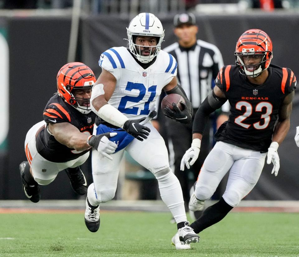 Cincinnati Bengals defensive tackle BJ Hill (92) dives to bring down Indianapolis Colts running back Zack Moss (21) on Sunday, Dec. 10, 2023, during a game against the Cincinnati Bengals at Paycor Stadium in Cincinnati.