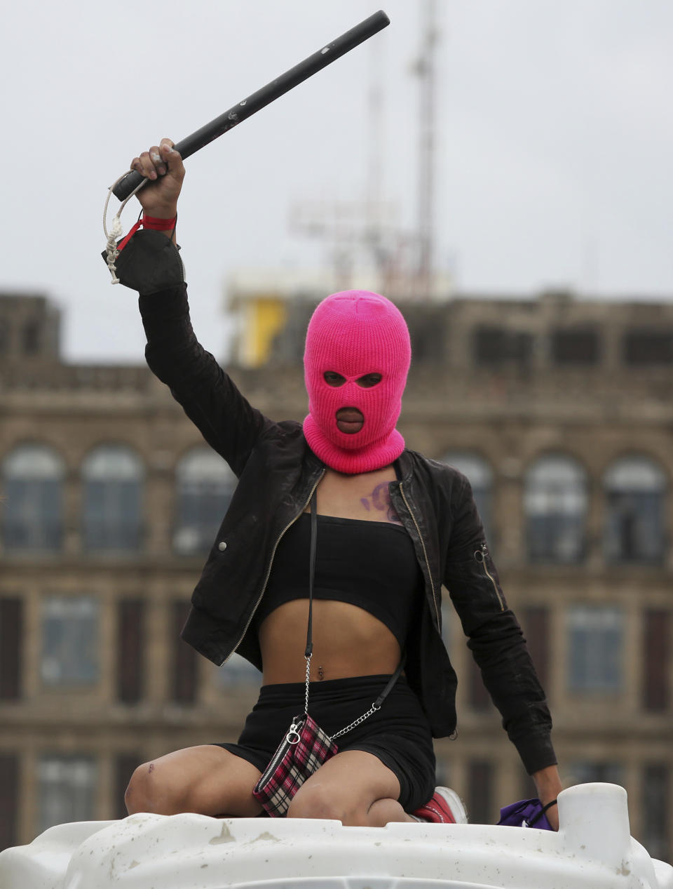 A demonstrator brandishes a baton in front of the National Palace during a march to commemorate International Women's Day and protest against gender violence, in Mexico City, Monday, March 8, 2021. (AP Photo/Ginnette Riquelme)