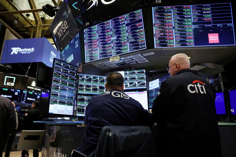 FILE PHOTO: Traders work on the floor of the NYSE in New York