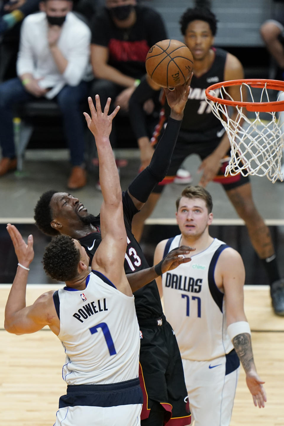 Miami Heat center Bam Adebayo (13) goes up for a shot against Dallas Mavericks center Dwight Powell (7) and guard Luka Doncic (77) during the second half of an NBA basketball game, Tuesday, May 4, 2021, in Miami. (AP Photo/Wilfredo Lee)