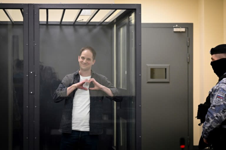 US journalist Evan Gershkovich, arrested on espionage charges, shapes a heart with his hands inside a defendants' cage in a Moscow court (Natalia KOLESNIKOVA)