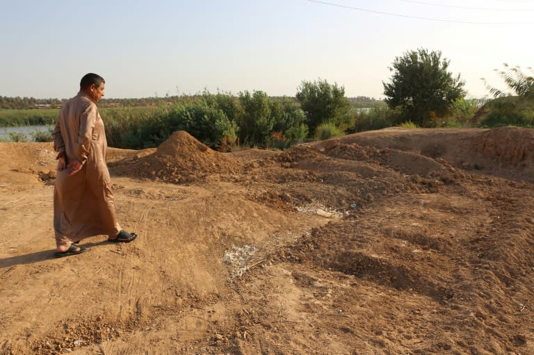 An Iraqi man inspects the site of a mass grave of Islamic State (IS) fighters in Dhuluiyah, north of Baghdad