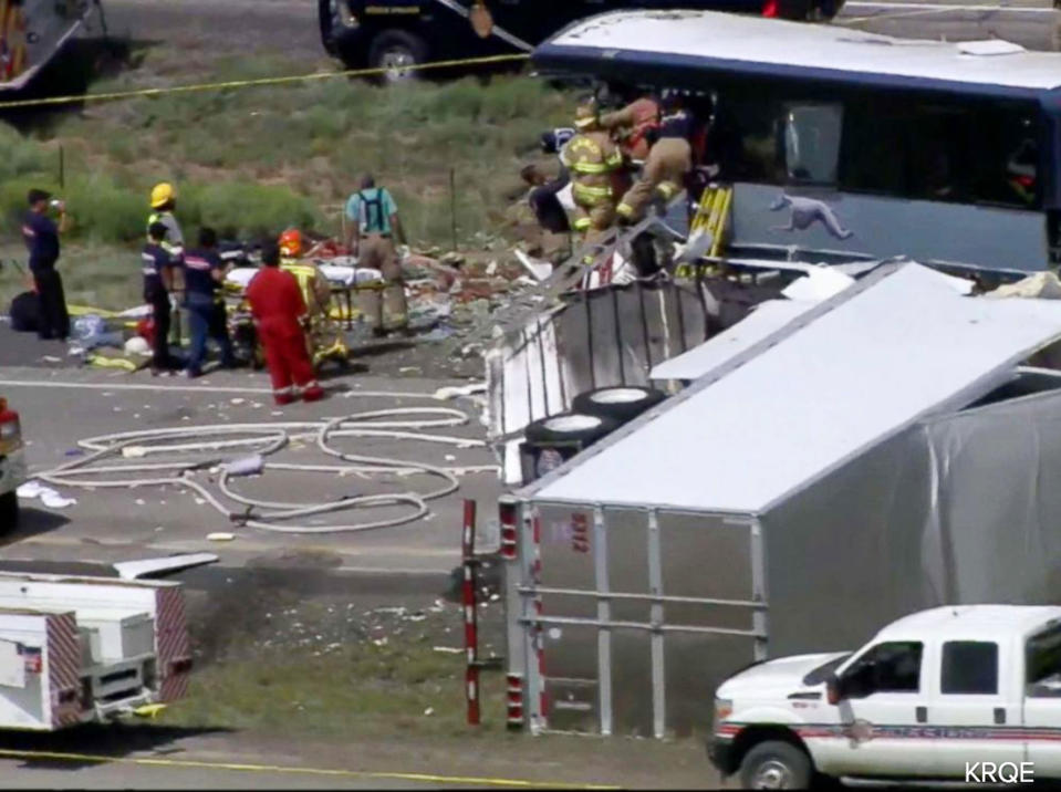 This photo from video provided by KQRENews13 shows first responders working the scene of a collision between a Greyhound passenger bus and a semi-truck on Interstate 40 near the town of Thoreau, N.M., near the Arizona border, Thursday, Aug. 30, 2018. Multiple people were killed and others were seriously injured. Officers and rescue workers were on scene but did not provide details about how many people were killed or injured, or what caused the crash. (KQRENews13 via AP)