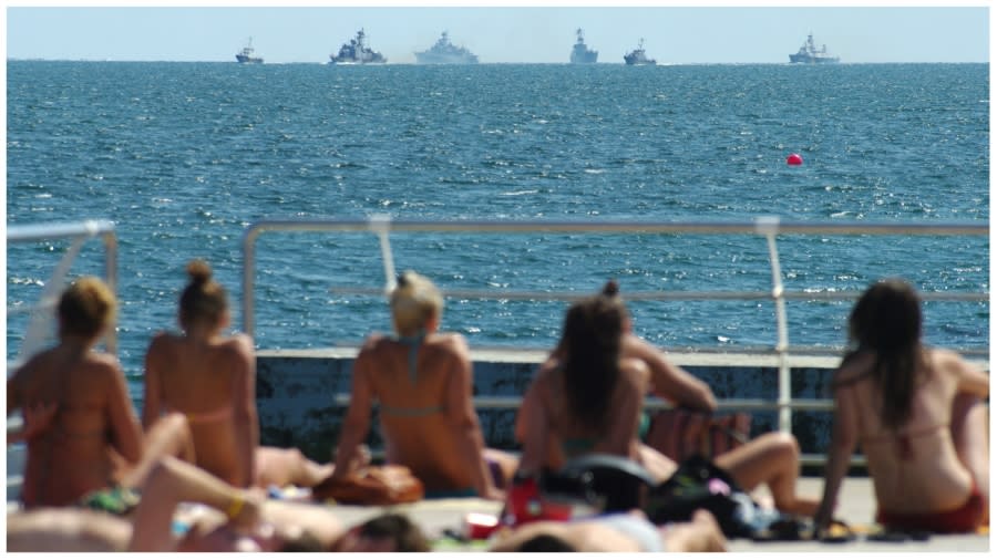 <span><em>Before the war: People sunbathe on a beach in the southern Ukrainian city of Odesa on August 19, 2014, as Ukrainian Navy ships take part in exercises.(ALEXEY KRAVTSOV/AFP via Getty Images)</em></span>