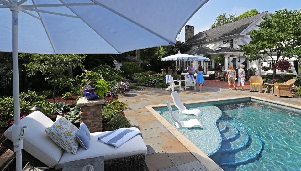 Visitors admire the decor of Joseph and Barb Jurcak's backyard garden during the 76th annual Hudson Garden Club Home and Garden Tour Saturday.