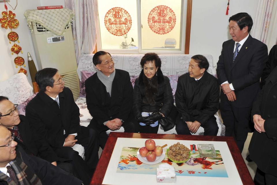 In this photo provided by China's Xinhua News Agency, Taiwan's Kuomintang Honorary Chairman Lien Chan, center left, visits the home of a villager at Guajiayu Village on the outskirts of Beijing, China, Tuesday, Feb. 18, 2014. Lien, also chairman of a foundation on cross-strait peaceful development, is leading a delegation from Taiwan for a four-day visit to China. (AP Photo/Xinhua, Chen Yehua) NO SALES