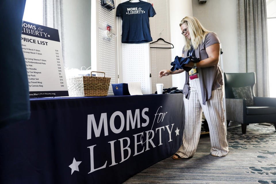 Jara Jeffries organizes Moms for Liberty apparel for sale in the hallway during the organization's inaugural summit on July 15, 2022, in Tampa. (Octavio Jones / Getty Images)