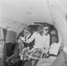 <p>Jacqueline Onassis wraps a blanket over her legs on a private jet in 1971.</p>