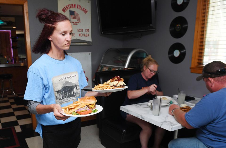 Niland's Cafe employee Ashley Markley serves food to customers on Wednesday in Colo. The cafe is now reopened under new management after being closed since Jan. 30.