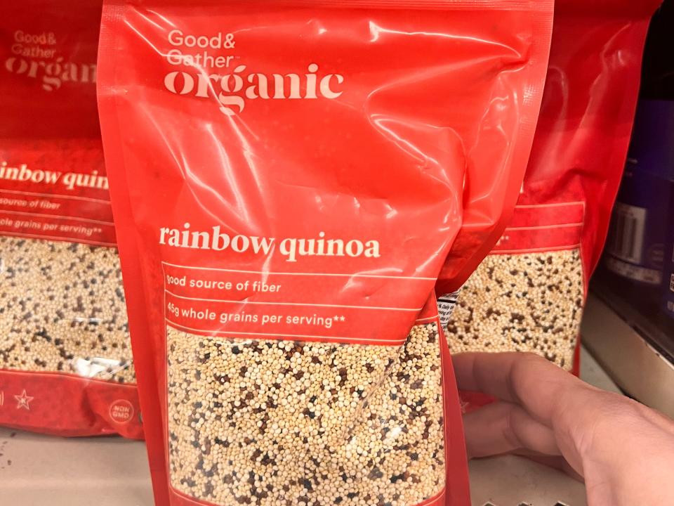 hand reaching for good and gather organic rainbow quinoa on the shelf at target