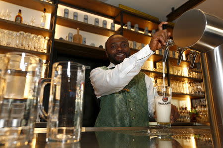 Michael Abbey, from Sierra Leone, poses while working as waiter in a restaurant called 'Muenchner Stuben' in Munich, Germany, October 12, 2015. REUTERS/Michaela Rehle