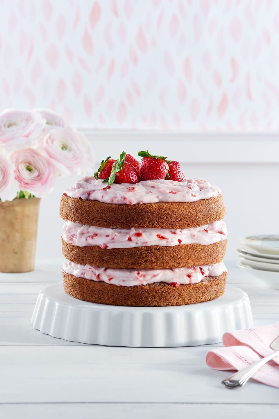 strawberry limeade cake with strawberry cream cheese frosting only between the layers and on top with the sides exposed