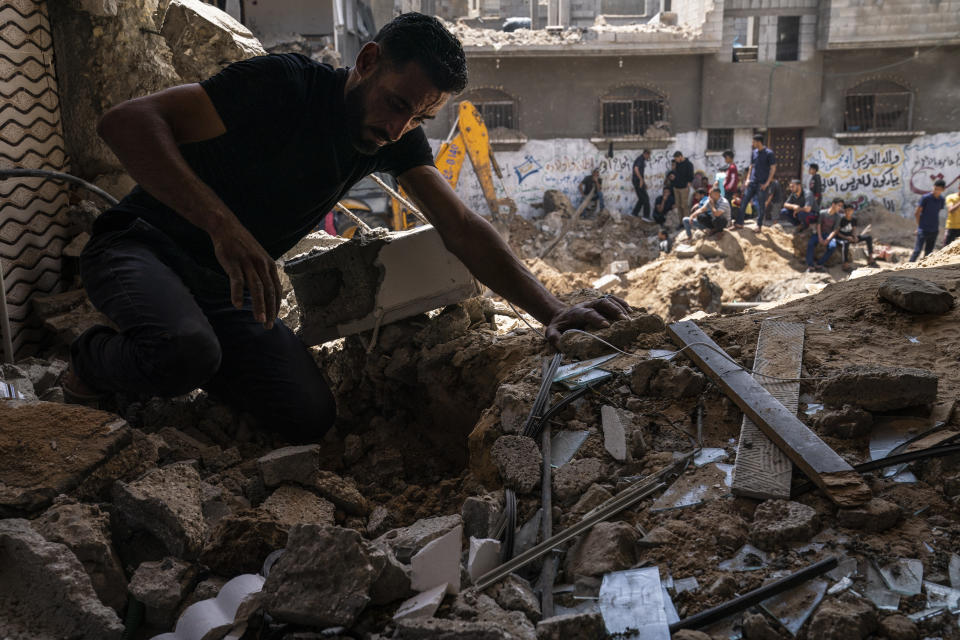 A man attempts to salvage valuables from the debris within the home of Nader al-Masri, a long-distance runner who participated in dozens of international competitions, including the 2008 Olympics, that was damaged when the home of Ramez al-Masri was destroyed by an air-strike prior to a cease-fire reached after an 11-day war between Gaza's Hamas rulers and Israel, Sunday, May 23, 2021, in Beit Hanoun, the northern Gaza Strip. (AP Photo/John Minchillo)