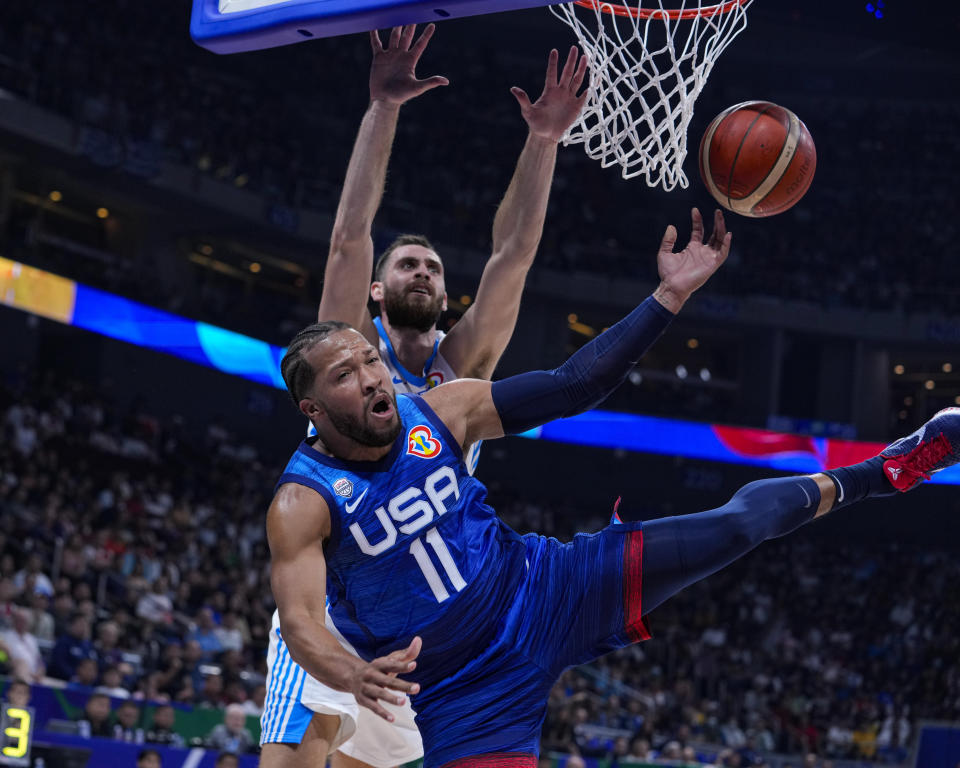 El estadounidense Jalen Brunson (11) recibe una falta del griego Georgios Papagiannis (14) en el partido del Mundial de basquetbol, el lunes 28 de agosto de 2023, en Manila. (AP Foto/Michael Conroy)