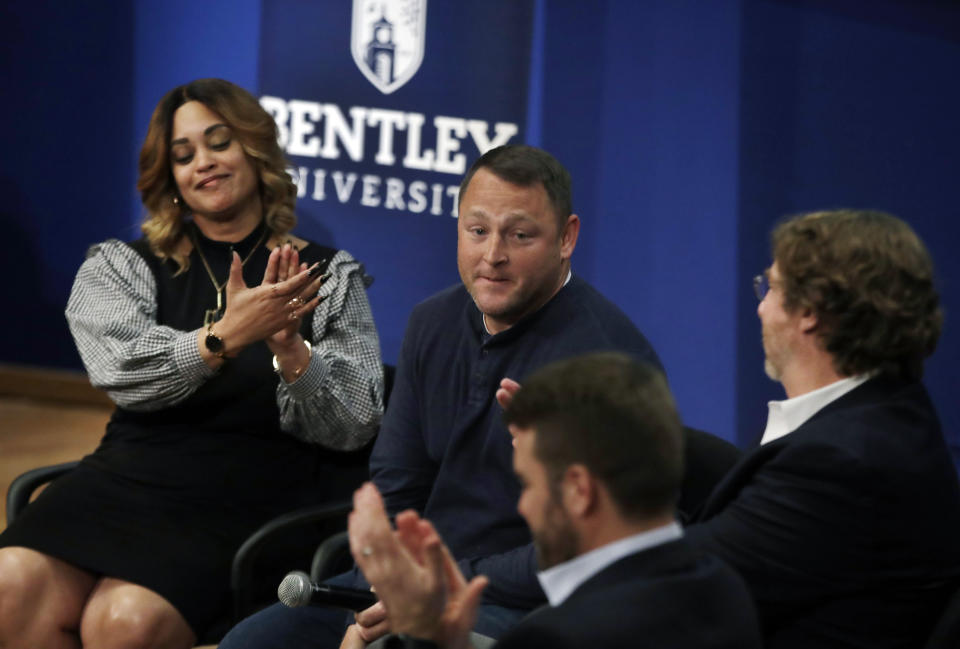 In this March 5, 2019 photo, panel members including Natalie Baucum, left, applaud Mike Duggan, middle, during an event at Bentley University, in Waltham, Mass., where professors and alumni shared some of their worst setbacks to illustrate that even successful people sometimes fail. A growing number of U.S. colleges are trying to "normalize" failure for a generation of students who increasingly struggle with stress, anxiety and the ability to bounce back from adversity. (AP Photo/Elise Amendola)