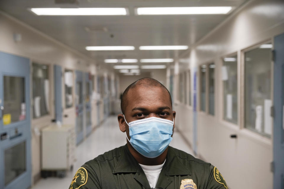 In this April 16, 2020, photo Christopher Lumpkin, a custody assistant, poses for a picture at the hospital ward of the Twin Towers jail in Los Angeles. Across the country first responders who've fallen ill from COVID-19, recovered have begun the harrowing experience of returning to jobs that put them back on the front lines of America's fight against the novel coronavirus. (AP Photo/Chris Carlson)