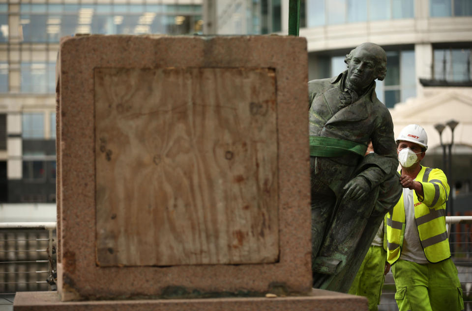 Workers take down a statue of slave owner Robert Milligan at West India Quay, east London as Labour councils across England and Wales will begin reviewing monuments and statues in their towns and cities, after a protest saw anti-racism campaigners tear down a statue of a slave trader in Bristol.