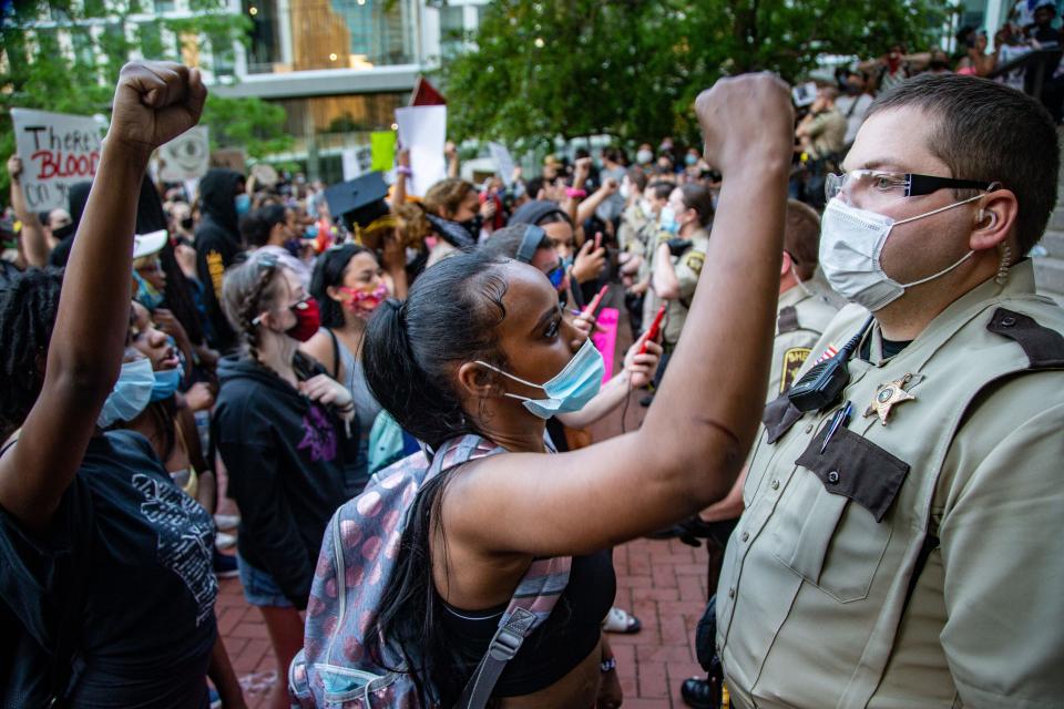 Protesters chant in the face of sheriffs deputies during a protest in front of the Hennepin County government center on May 28, 2020.