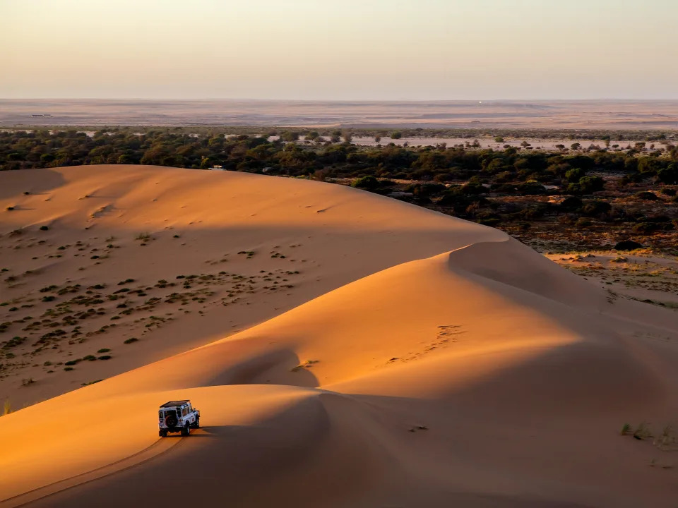 A car driving in the sand dunes of Dubai.