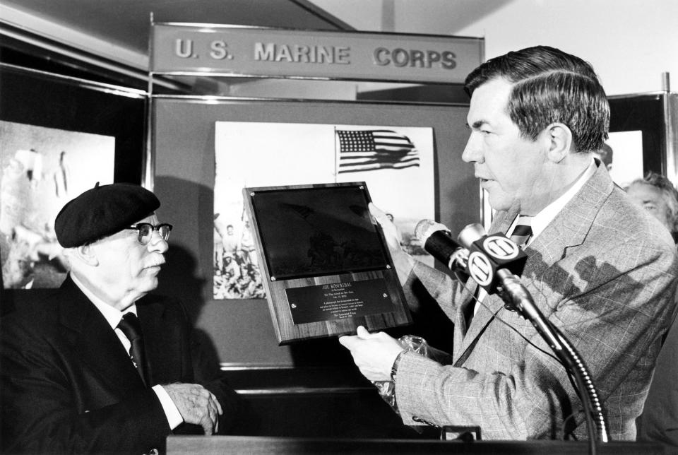 FILE - Hal Buell of The Associated Press presents an AP award to Pulitzer Prize-winning photographer Joe Rosenthal on his retirement at Treasure Island Naval Base, San Francisco, March 24, 1981. Buell, who led The Associated Press' photo operations from the darkroom era into the age of digital photography over a four-decade career with the news organization that included 12 Pulitzer Prizes and running some of the defining images of the Vietnam War, has died. Buell died Monday, Jan. 29, 2024, in Sunnyvale, Calif., where his daughter lived, after battling pneumonia. He was 92. (AP Photo, File)