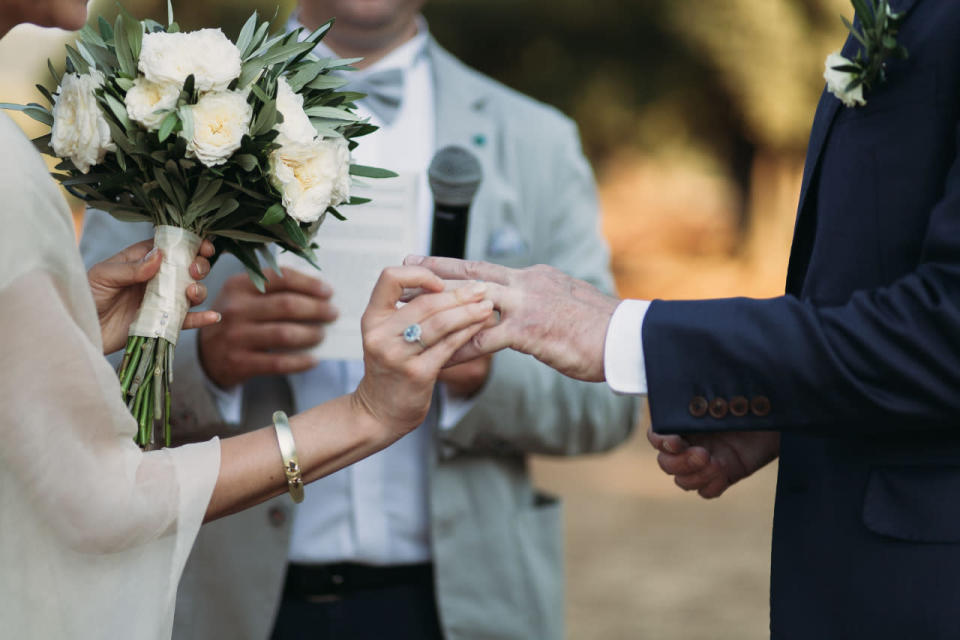 The bride wore minimal jewelry and carried a lush white bouquet.