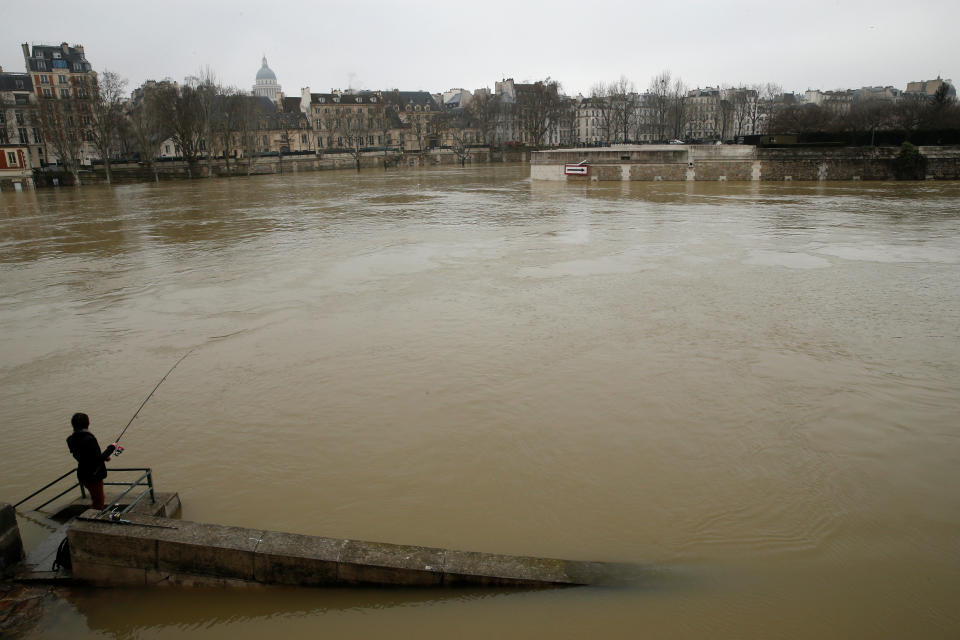 <p>A man fishes on the flooded banks of the River Seine in Paris, France, after days of almost non-stop rain caused flooding in the country, Jan. 27, 2018. (Photo: Pascal Rossignol/Reuters) </p>