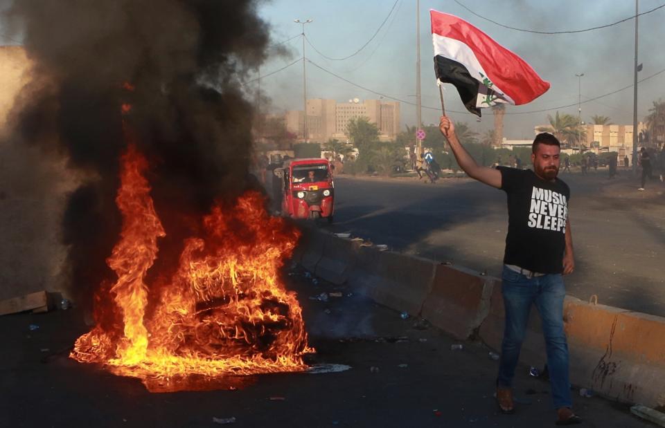 Anti-government protesters set fires and close a street during a demonstration in Baghdad, Iraq, Friday, Oct. 4, 2019. Security forces opened fire directly at hundreds of anti-government demonstrators in central Baghdad, killing some protesters and injuring dozens, hours after Iraq's top Shiite cleric warned both sides to end four days of violence "before it's too late." (AP Photo/Khalid Mohammed)