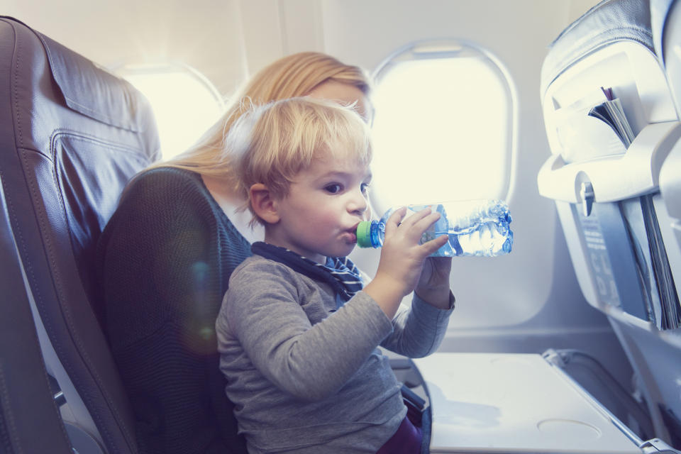Ein Kind trinkt Wasser im Flugzeug. (Bild: Getty Images)