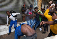 <p>A vigilante mob attacks a Nigerian migrant outside a church in Pretoria, South Africa, Feb. 18, 2017. Police fired stun grenades, rubber bullets and water cannon Friday as the latest wave of anti-immigrant protests broke out in South Africa’s capital. (Photo: James Oatway/Reuters) </p>