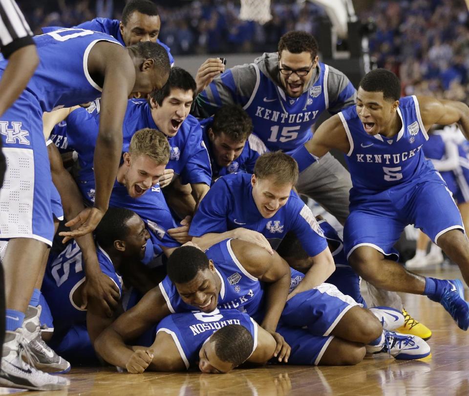 Kentucky players celebrate on the court after their 74-73 victory over Wisconsin in an NCAA Final Four tournament college basketball semifinal game Saturday, April 5, 2014, in Arlington, Texas. (AP Photo/Eric Gay)