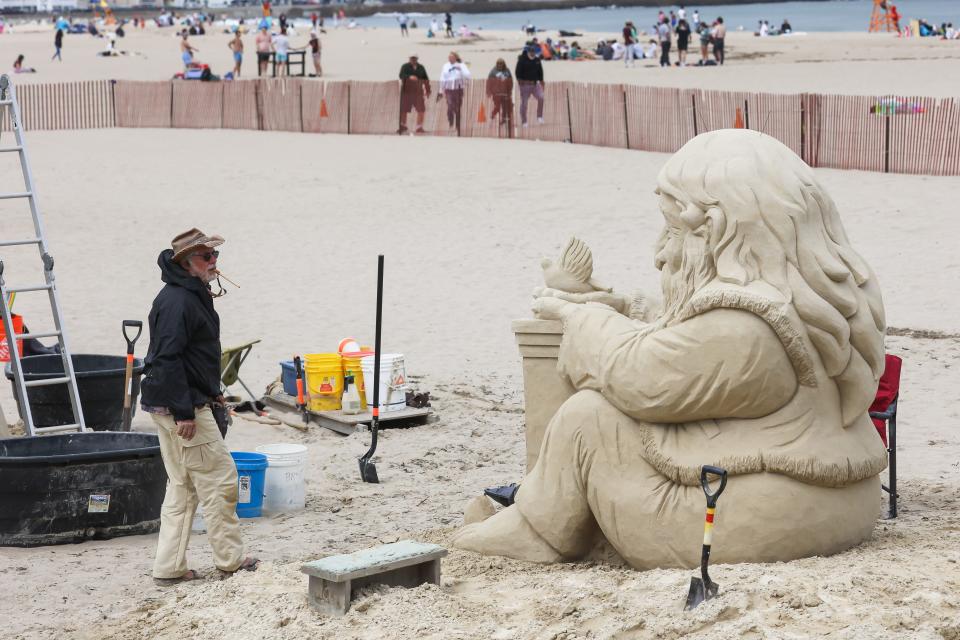 Justin Gordon, of Groveland Massachusetts, puts the finishing touches on his creation "Let There Be Peace" at the 2022 Hampton Beach Master Sand Sculpting Classic Saturday, June 18.