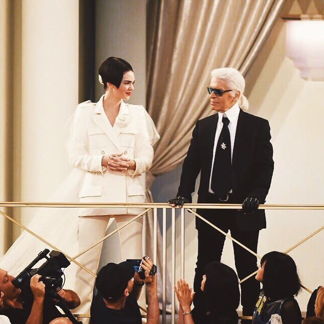 Well this is certainly a new look for Kendall Jenner! The 19-year-old supermodel walked the Chanel runway on Tuesday, trading in her long dark locks for a severe, stick-straight bob. Proving she can pull off just about any look, Kendall was a standout in an edgy off-white pantsuit complete with a long train. <strong>WATCH: Kendall Jenner Flashes Her Butt Cheeks In Shortest Shorts Imagineable</strong> Getty Images Getty Images Getty Images Cementing her status in the high-fashion world, Kendall was the chosen model to strike a pose with legendary Chanel designer Karl Lagerfeld at the end of the show, which she of course happily Instagrammed about. "Of course I said yes. #Chanel #HauteCouture," she wrote. Check out Kendall and Karl looking like a bride and groom. The reality star's already made an impressive mark on Paris Fashion Week, walking the Versace runway on Sunday. Getty Images <strong>WATCH: Kendall Jenner and a Shirtless Justin Bieber Star in Sexy 'Vogue' Shoot</strong> In March, Kendall memorably graced the Chanel runway, but with her bestie, supermodel Cara Delevingne. Watch below: