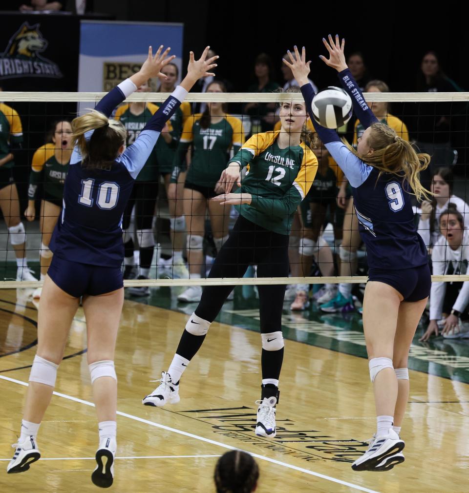 Katie Gielas, an Ursuline sophomore, spikes the ball past two defenders. Ursuline Academy defeated Magnificat, 3-1, on Nov. 12, 2022, at the Wright State Nutter Center to earn the Division I state volleyball championship.
