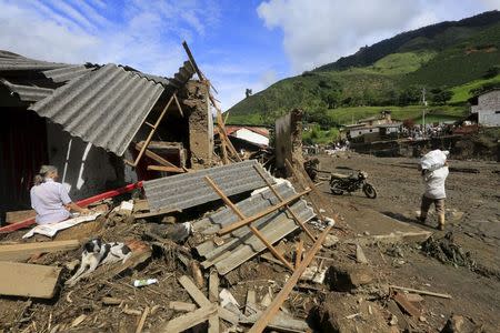 A woman eats her breakfast at her damaged house after a landslide sent mud and water crashing onto homes close to the municipality of Salgar in Antioquia department, Colombia May 19, 2015. REUTERS/Jose Miguel Gomez