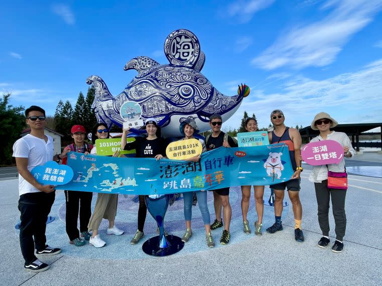 澎湖自行車跳島嘉年華辦理踩線團，由鐵人美女雙主播夏嘉璐（右五）、侯以理（右三）及土耳其裔自行車女神舒（左四）舒領軍於澎湖新地標嗨鼠前合影。官方提供